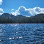 Canoe on water with large rolling hills