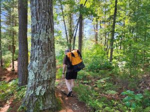 man portaging yellow backpack